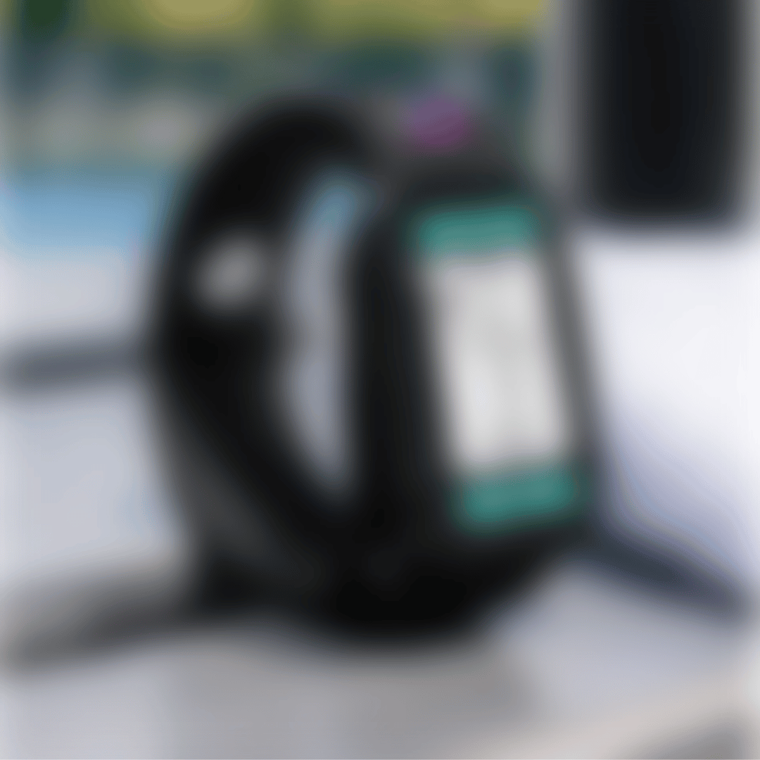 A black smartwatch with a teal screen display, shown in a close-up shot that is heavily blurred.